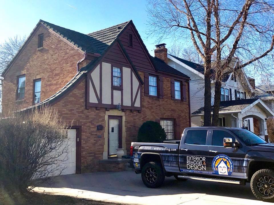 single story tan home with brick details completed by Exterior Remodel & Design