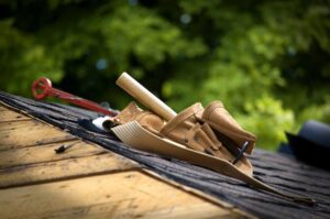 suede tool belt resting on shingles on roof