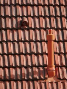 close up of vent pipe on a steep red roof